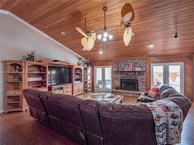 living room with dark hardwood / wood-style floors, wood walls, a brick fireplace, and french doors