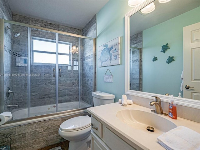 full bathroom featuring shower / bath combination with glass door, toilet, and vanity