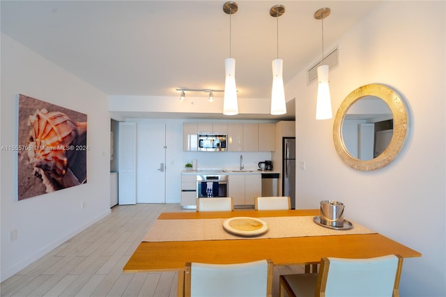 dining room with sink and rail lighting