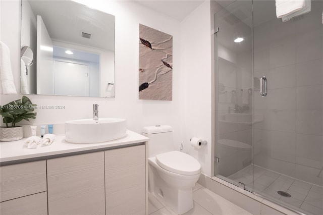 bathroom with oversized vanity, toilet, a shower with door, and tile flooring