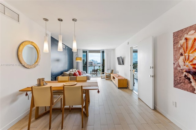 dining room with light hardwood / wood-style floors and a wall of windows