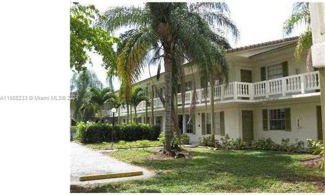 rear view of house with a lawn and a balcony