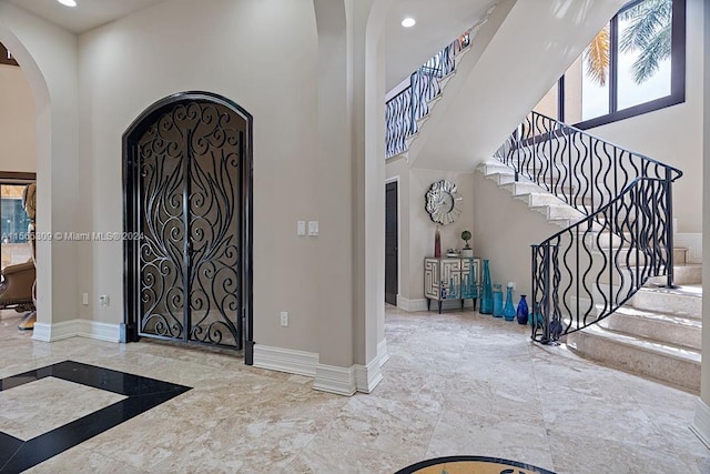 tiled foyer with a towering ceiling