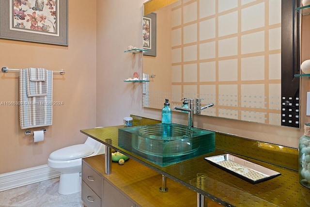 bathroom with toilet, vanity, and tile flooring