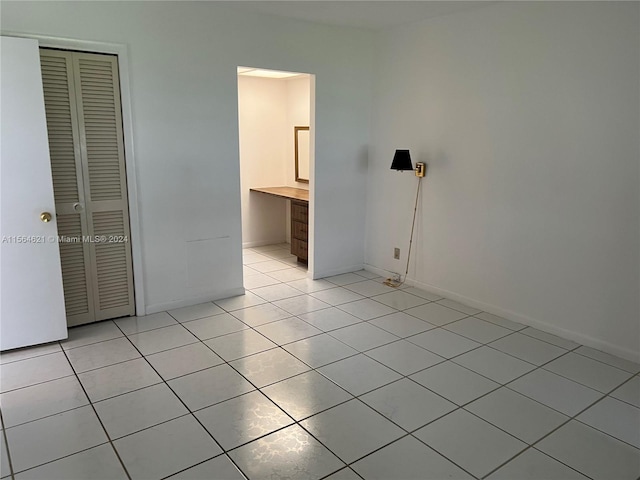 unfurnished bedroom with light tile flooring and a closet