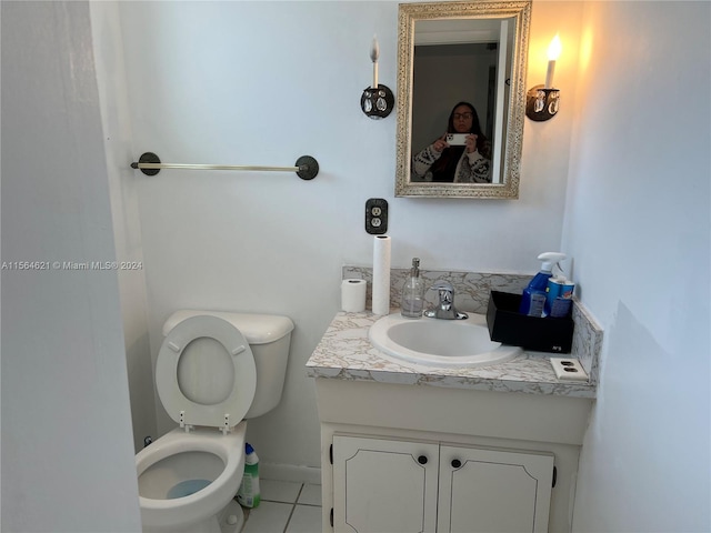 bathroom with tile flooring, toilet, and vanity with extensive cabinet space