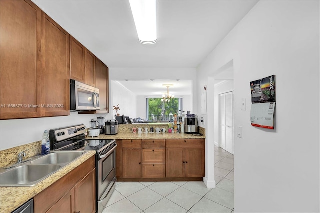 kitchen with sink, appliances with stainless steel finishes, light stone counters, and light tile flooring