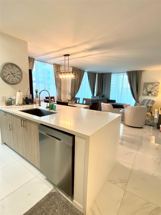 kitchen featuring sink, a healthy amount of sunlight, decorative light fixtures, and stainless steel dishwasher