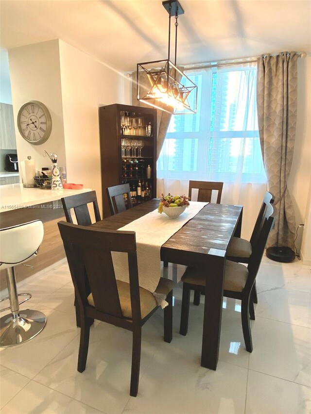 dining space featuring a chandelier and light tile floors