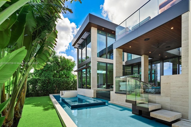 view of pool with ceiling fan and a lawn