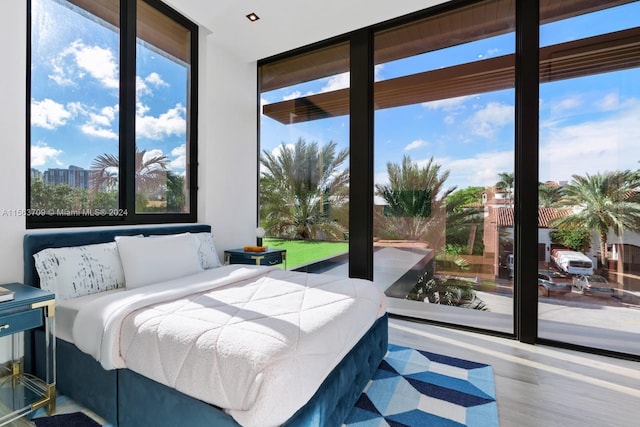 bedroom featuring wood finished floors and floor to ceiling windows