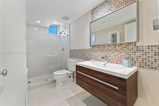 bathroom featuring tiled shower, tile patterned floors, toilet, tile walls, and vanity