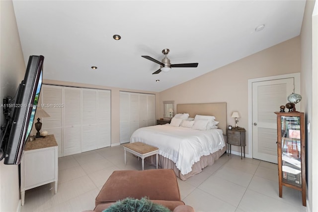 bedroom featuring ceiling fan, lofted ceiling, light tile patterned floors, and two closets