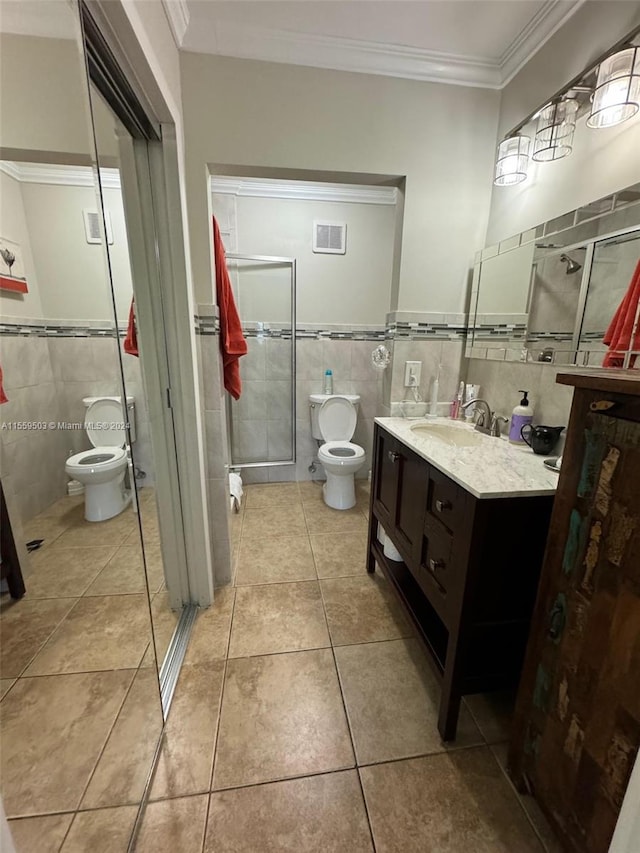 bathroom with tile walls, toilet, vanity, and tile flooring