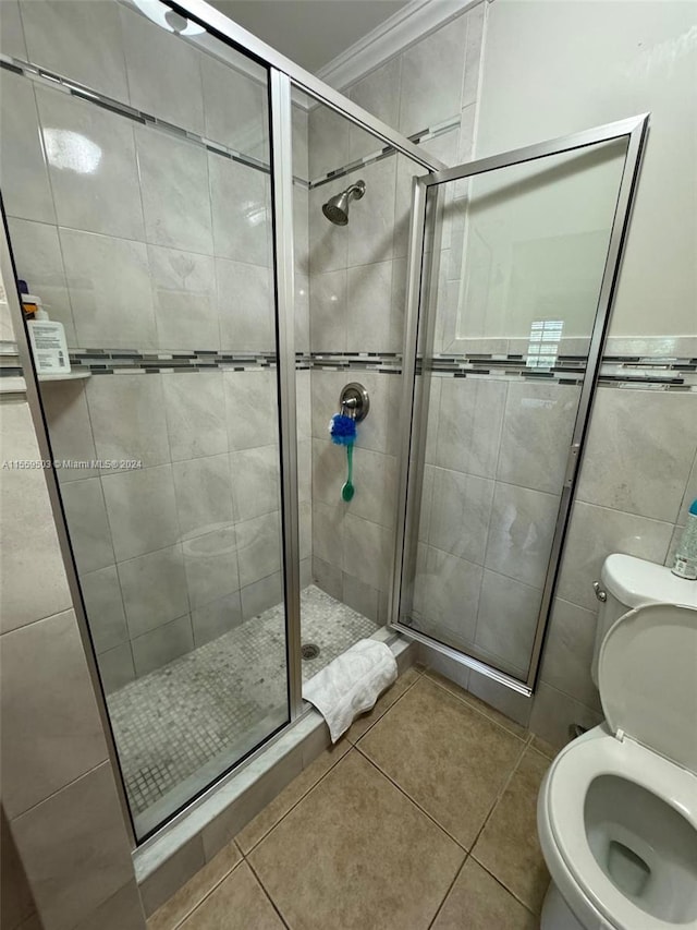 bathroom featuring tile floors, tile walls, toilet, and an enclosed shower