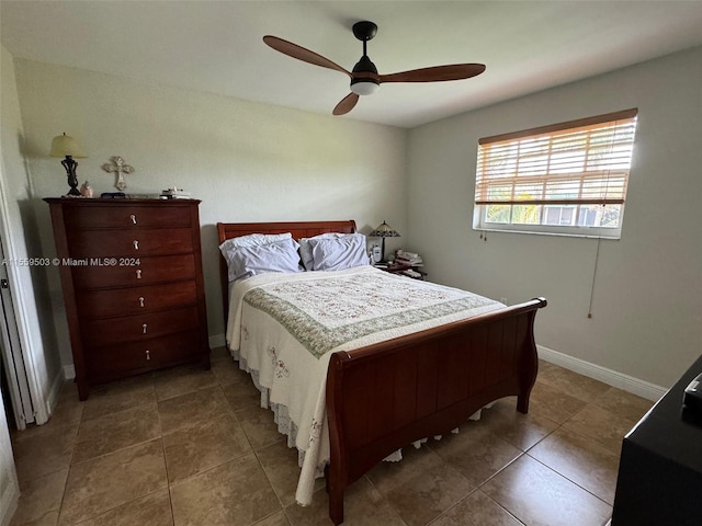 bedroom with ceiling fan and dark tile flooring