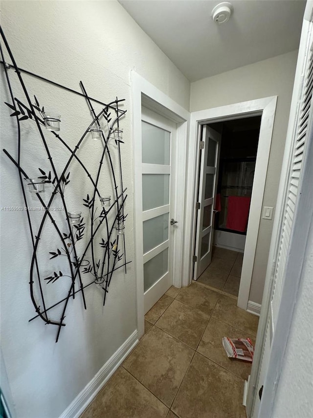 hall with dark tile flooring