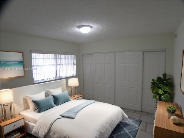 bedroom with a textured ceiling and a closet