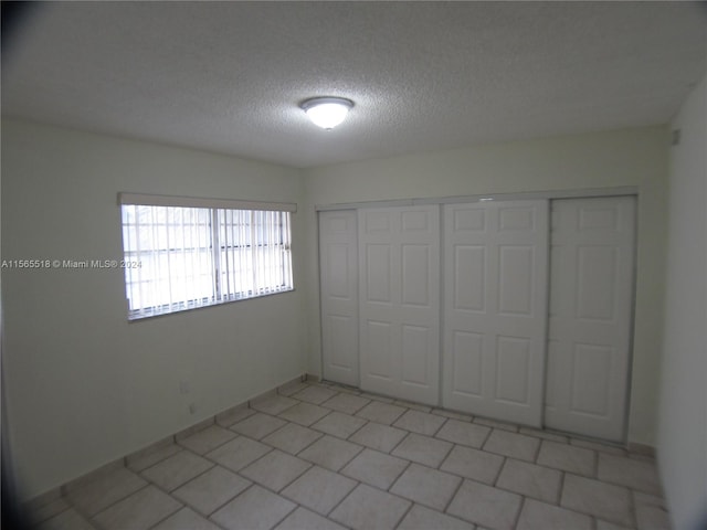 unfurnished bedroom with a closet and a textured ceiling