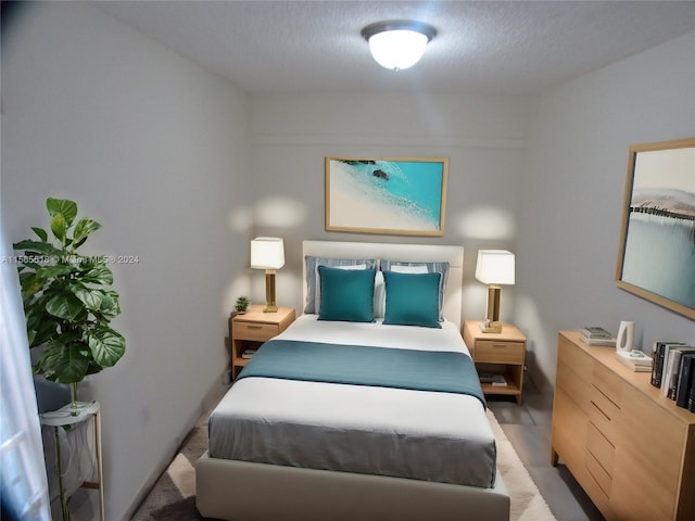 bedroom featuring light carpet and a textured ceiling