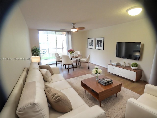 living room featuring light wood-type flooring and ceiling fan