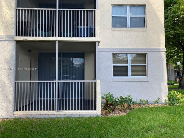 exterior space with a balcony and a lawn