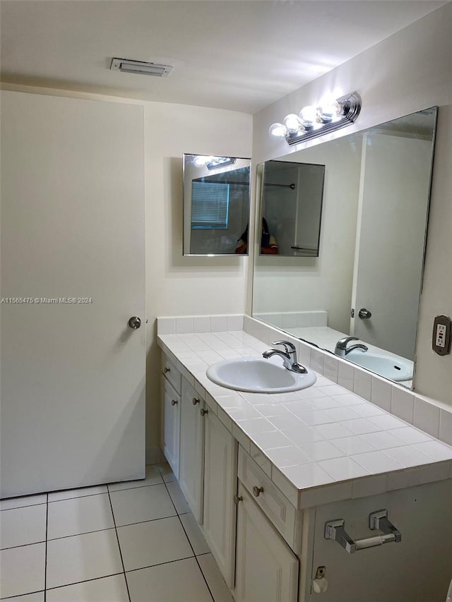 kitchen with white cabinets, white appliances, kitchen peninsula, light wood-type flooring, and tile counters