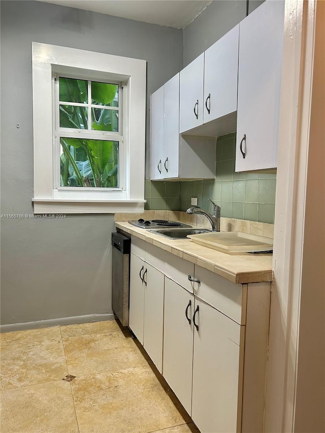 kitchen featuring white cabinets, stainless steel dishwasher, sink, and decorative backsplash