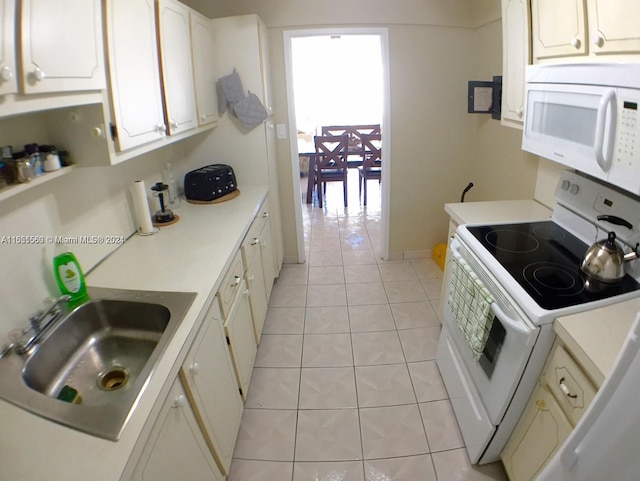 kitchen with white appliances, a healthy amount of sunlight, white cabinetry, and light tile floors