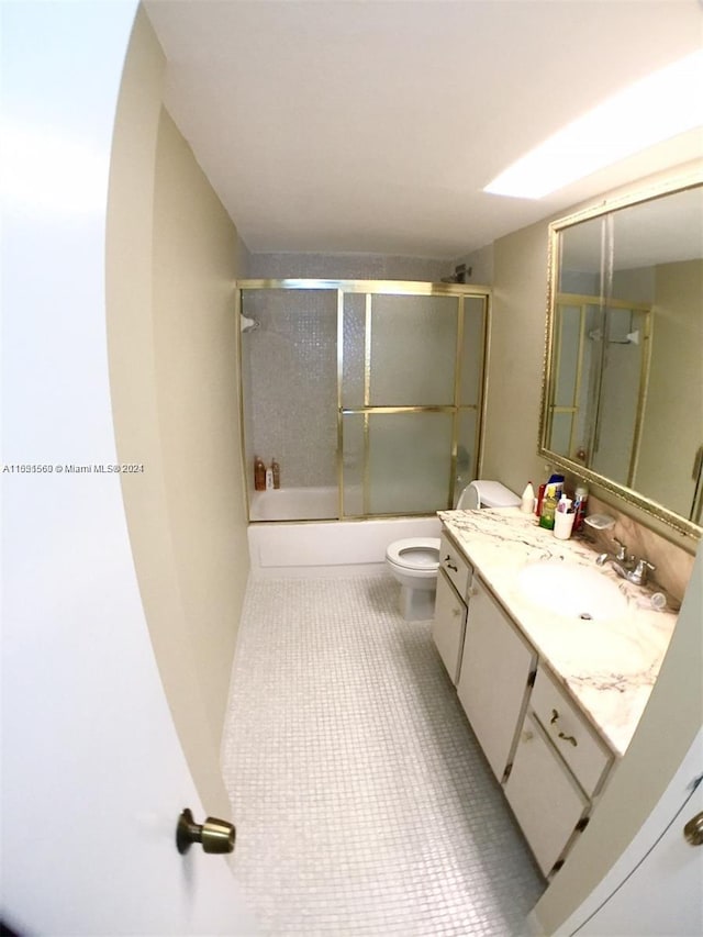 full bathroom featuring vanity, combined bath / shower with glass door, tile floors, and toilet