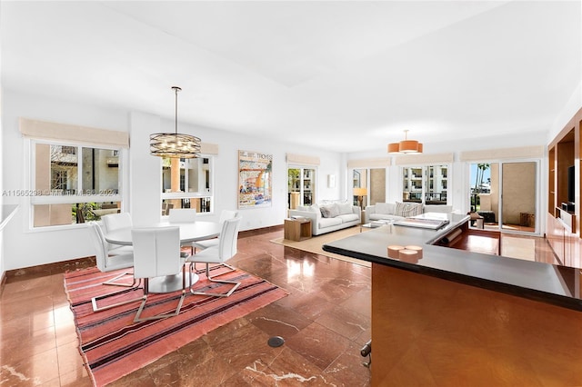 living area with baseboards and a chandelier