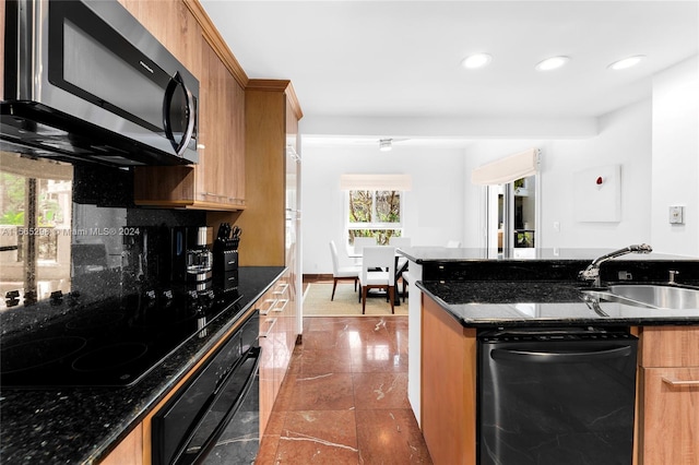 kitchen with dark tile patterned floors, black appliances, sink, decorative backsplash, and dark stone countertops