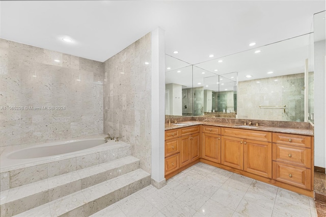 bathroom featuring vanity, independent shower and bath, and tile walls