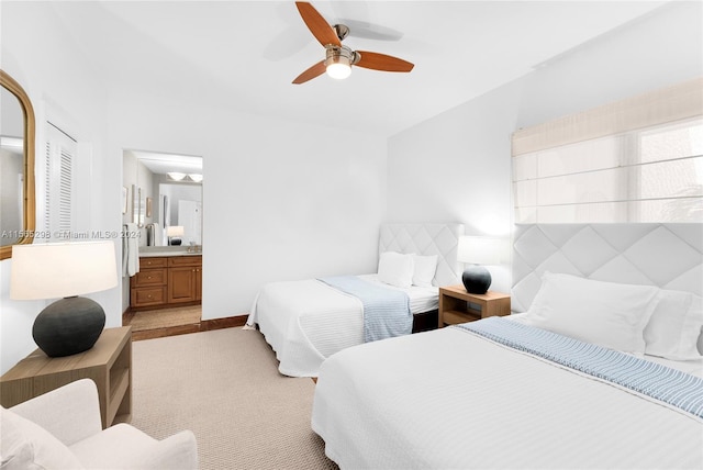 bedroom with ensuite bath, ceiling fan, and light colored carpet