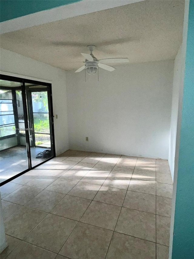 spare room with tile flooring, ceiling fan, and a textured ceiling