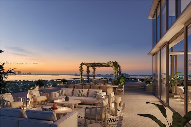 patio terrace at dusk featuring a water view