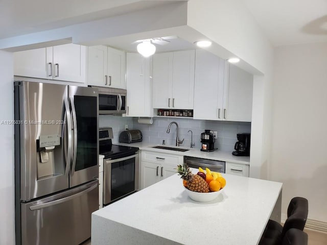 kitchen featuring backsplash, stainless steel appliances, white cabinetry, and sink