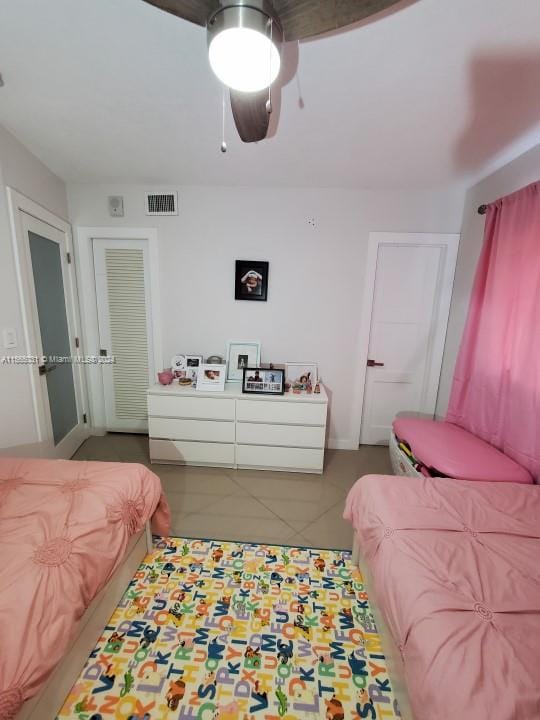 bedroom with light tile floors and ceiling fan