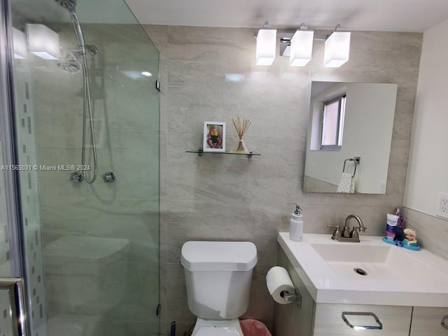 bathroom featuring tile walls, toilet, and vanity