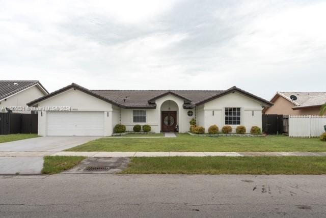 ranch-style house featuring a garage and a front yard