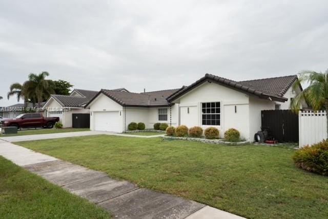 single story home with a garage and a front lawn