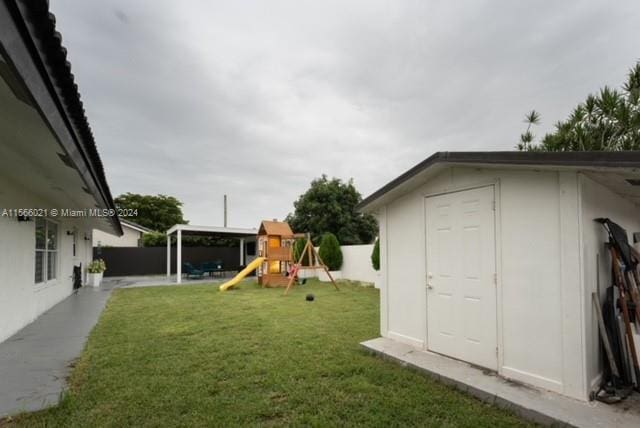 view of yard with a playground and a shed