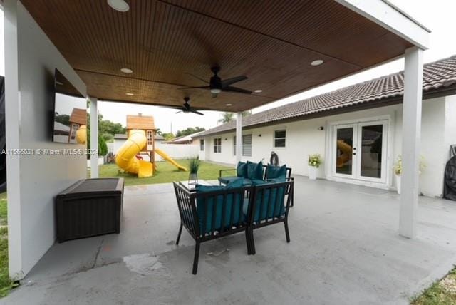 view of patio featuring ceiling fan, outdoor lounge area, and a playground