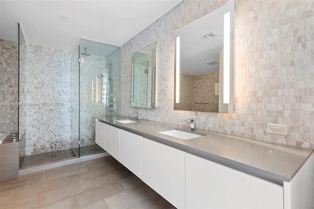 bathroom with tile flooring, a shower with shower door, tile walls, and double vanity