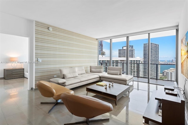 living room with a water view, floor to ceiling windows, and light tile floors