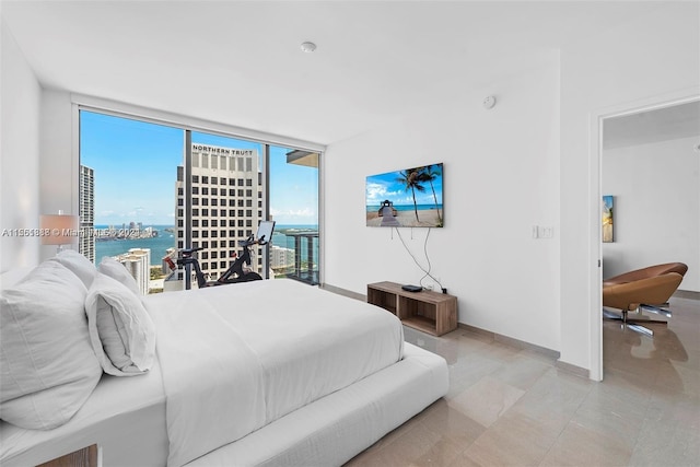 tiled bedroom featuring a water view and expansive windows