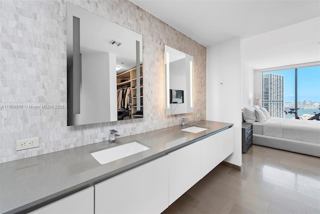 bathroom featuring double sink vanity, backsplash, and tile floors