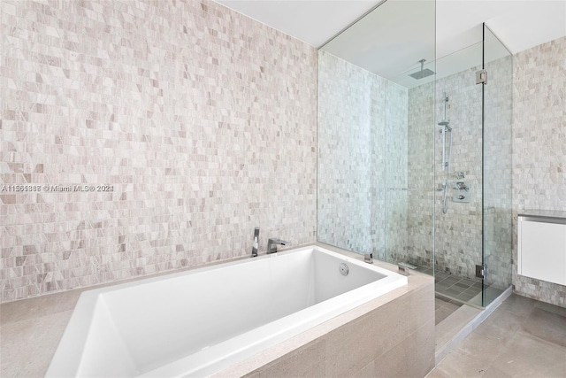 bathroom featuring tile walls, tile floors, and independent shower and bath