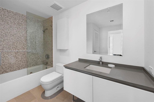 full bathroom featuring tiled shower / bath combo, vanity, toilet, and tile floors