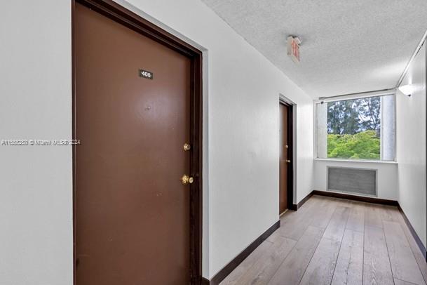 hallway featuring a textured ceiling and light hardwood / wood-style flooring